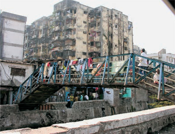 Re-housing-Mumbai’s-Slum-Dwellers-narrow-bridge-drainage-channel-slum